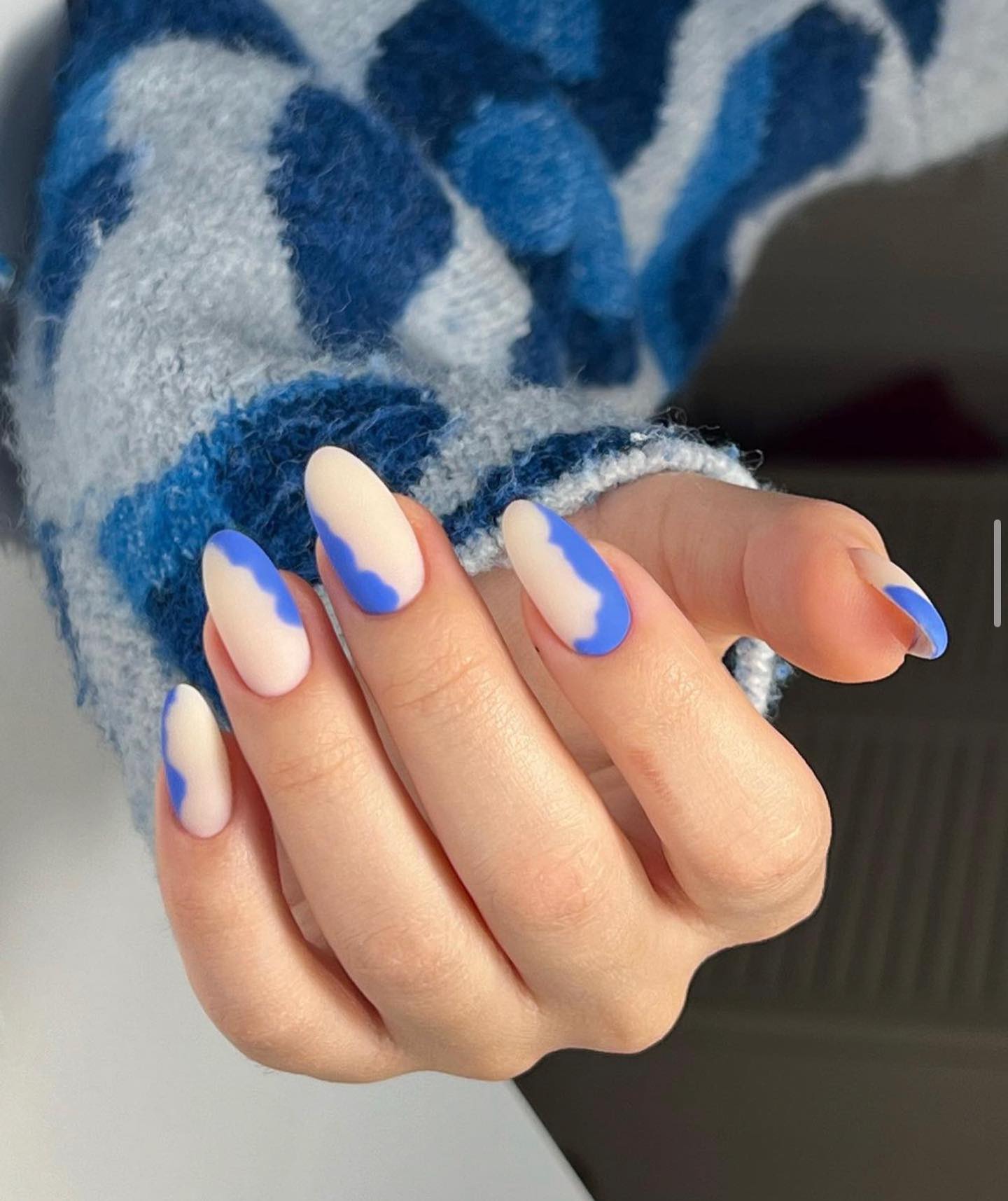 Nude almond nails with blue wave accents