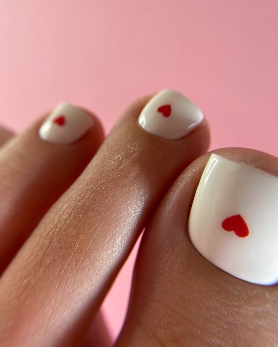 White pedicure with tiny red hearts