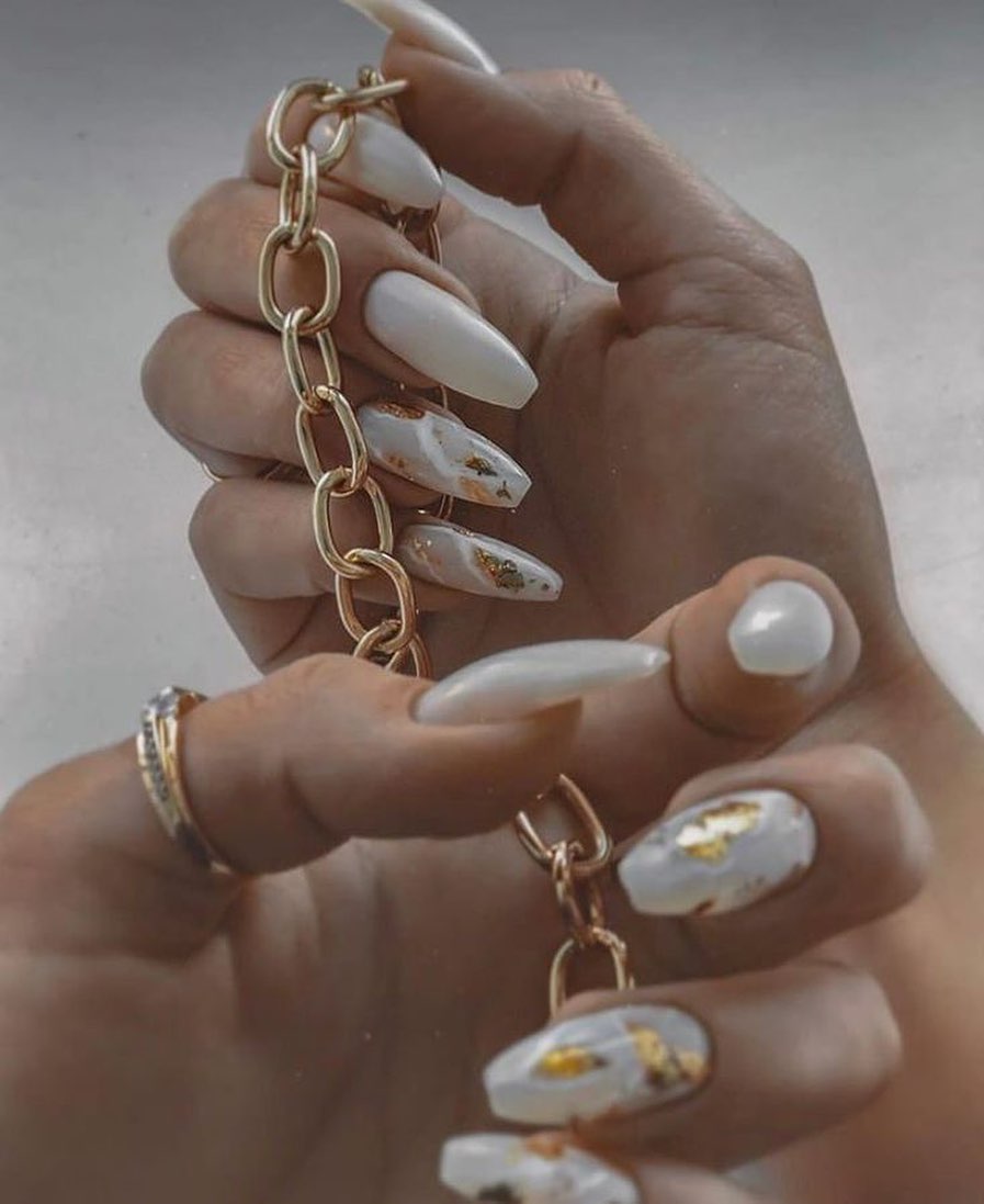 Long white almond nails with gold foil accents