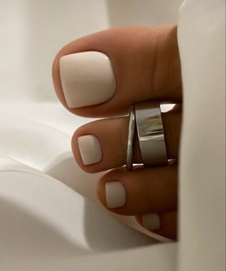 Cream pedicure with a silver toe ring