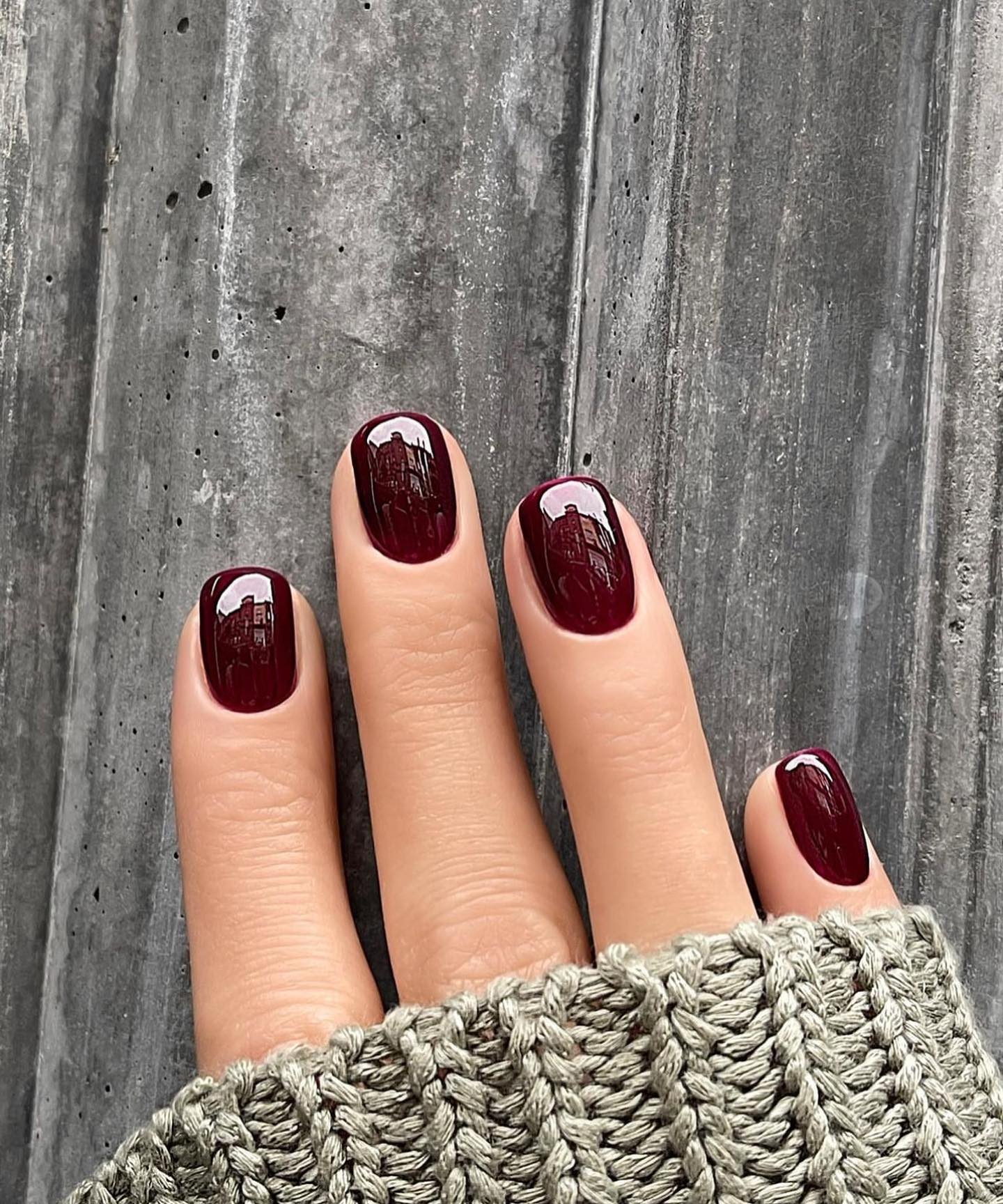 Short deep cherry nails on a wooden background